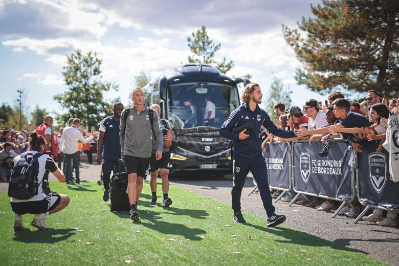 Team arrival by coach, welcomed by supporters
